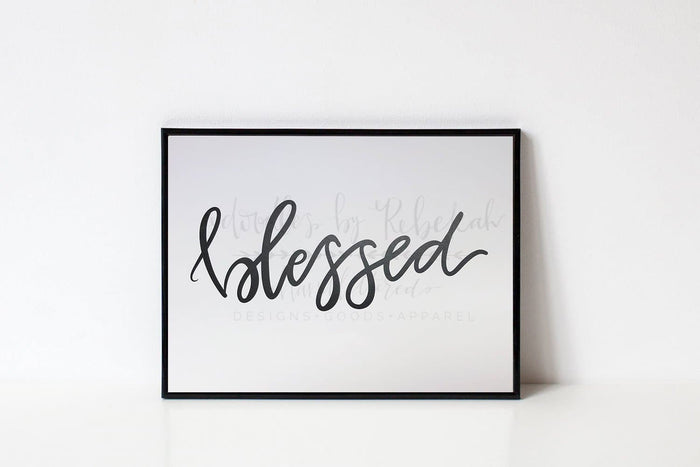 An 8x10 framable print with the word 'Blessed' written in a cursive script font, predominantly in black ink on a white background.