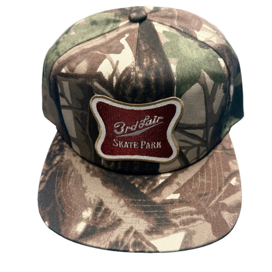 Camouflage cap with a red and white logo on a blue surface