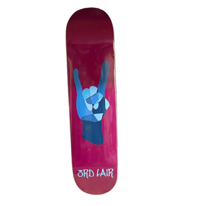 Pink skateboard deck with blue hand gesture design against a gray wall.