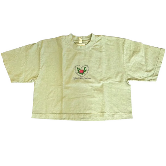 Light green t-shirt with a logo on a dark textured surface