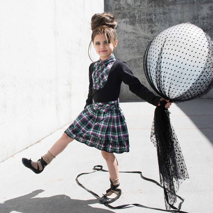 Young girl wearing a pleated tartan mini skirt with a casual top