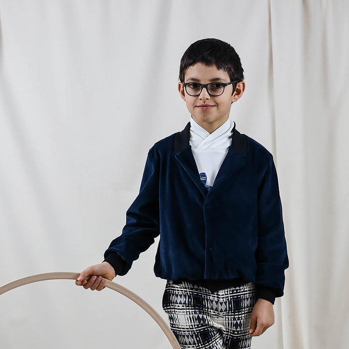 Child wearing a petrol blue velvet blazer for a formal outfit